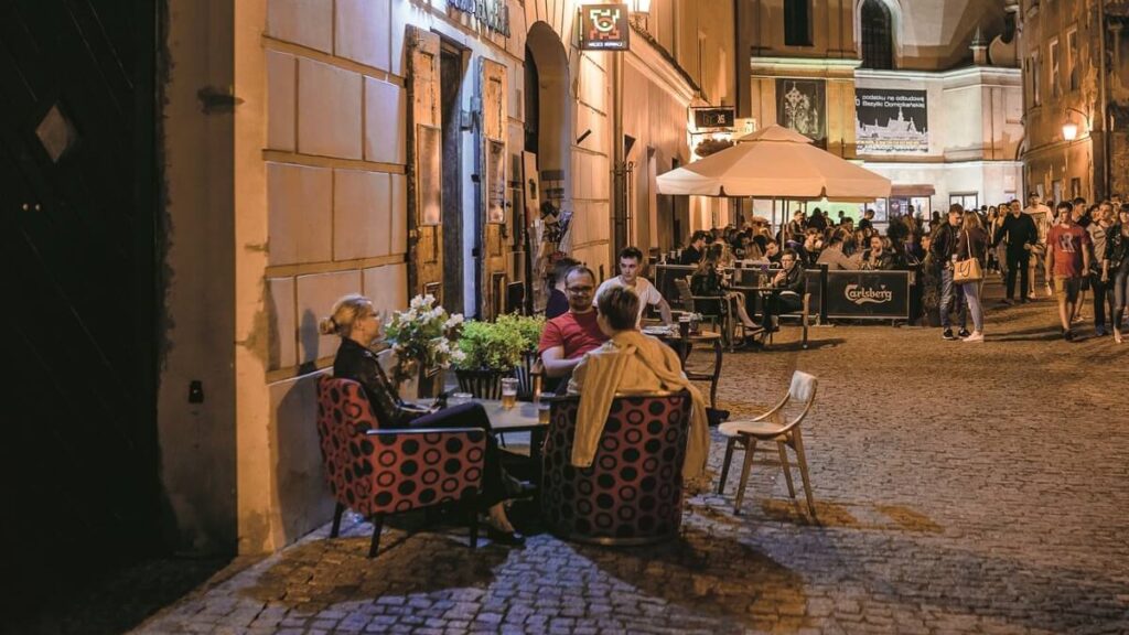 Ludzie siedzący przy restauracyjnych stolikach