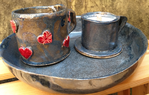 szare kubki i talerz wykonane z ceramiki ozdobione czerwonymi sercami
