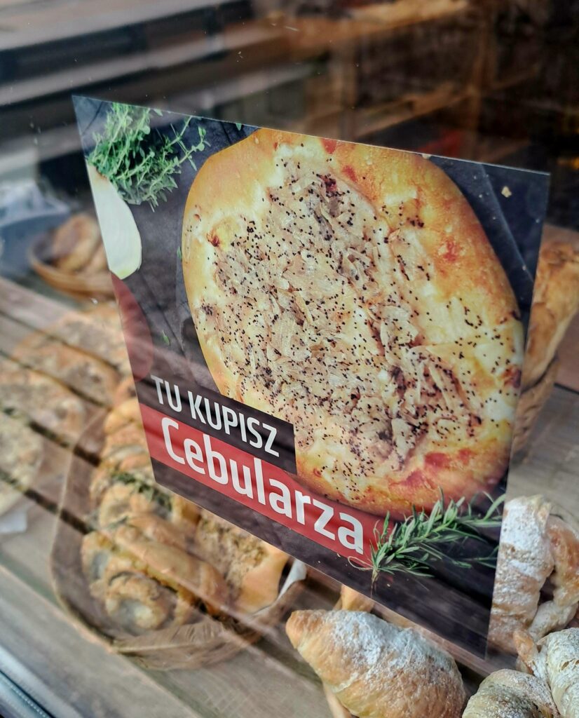 Naklejka na szybie piekarni z napisem "tu kupisz cebularza"