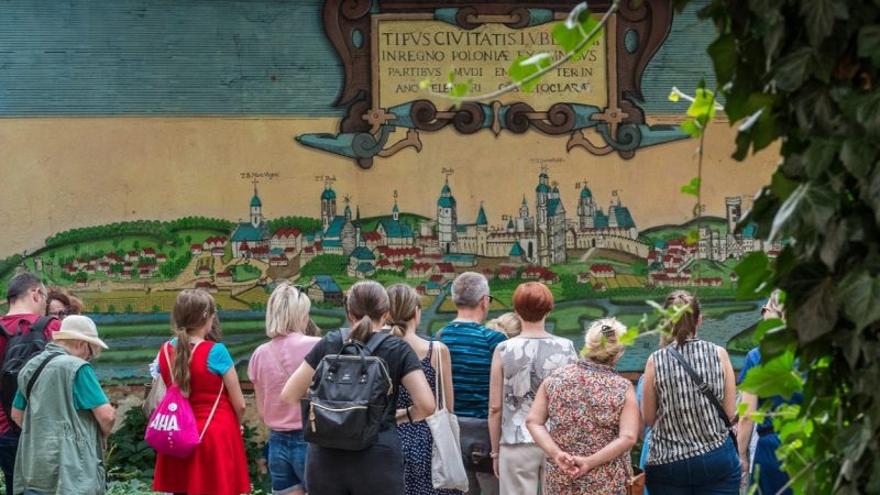 Grupa osób stojąca przed muralem na wycieczce z przewodnikiem